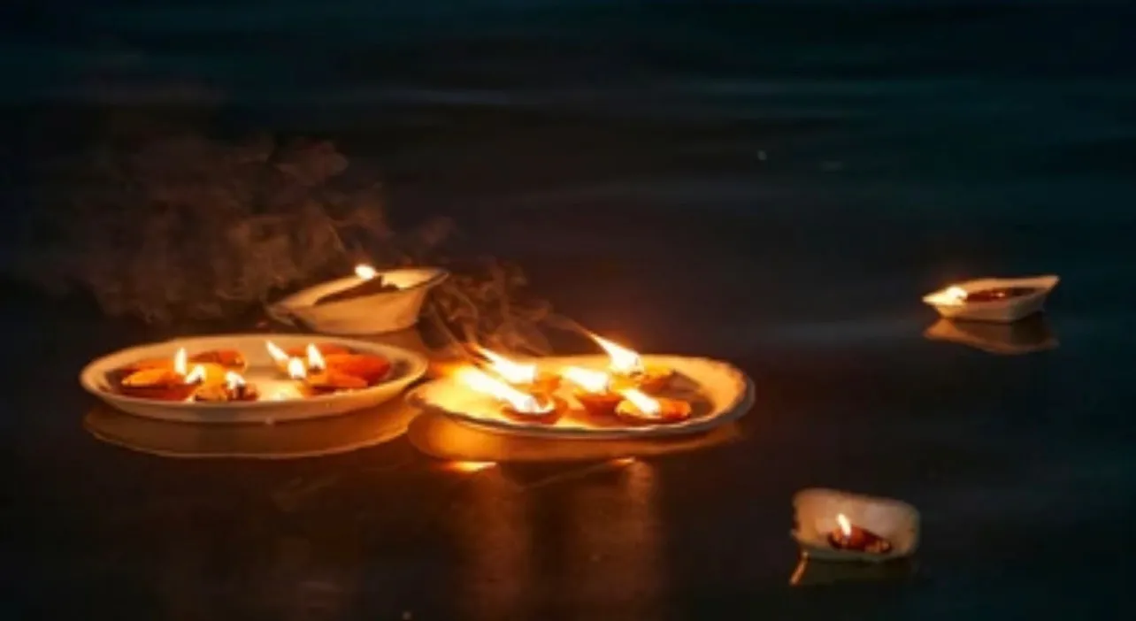 Candles floating on dark water